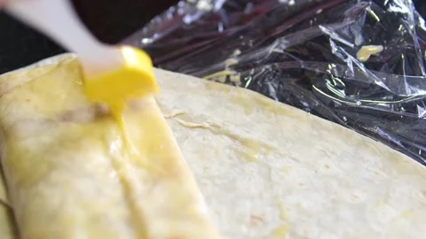 Brush with egg process of preparing doner, a young woman dressed in an apron in Stock Footage 309234241