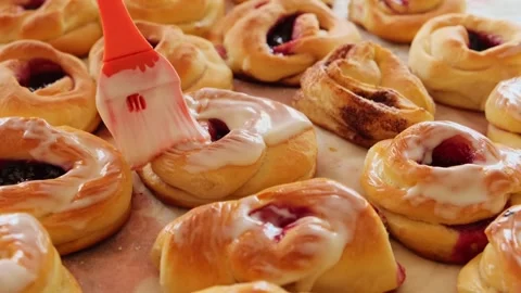 Brush greasing hot buns with cream. Stock Footage 243161405