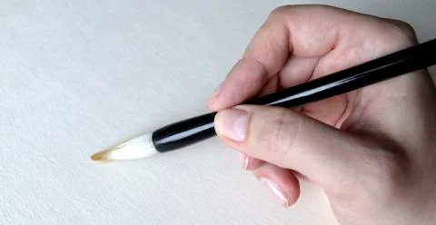Brush in hand for drawing on white Stock Photos