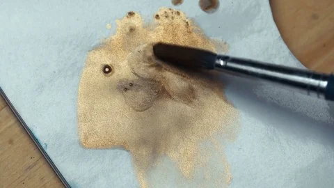 Brush macro mixes the paint on the paper palette - liquid gold. Stock Footage 75377853
