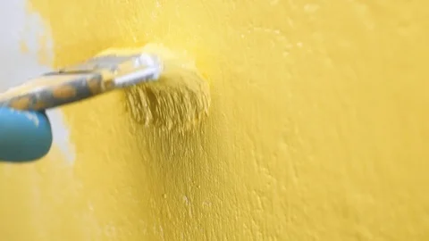 Brush moves up and down on white wall and paints it yellow. Wall painting Видео 123099997