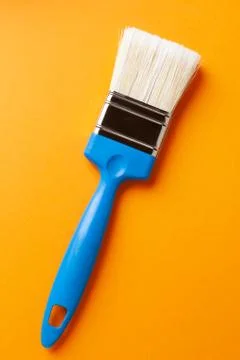 Brush on an orange background, vertical orientation, close-up. Stock Photos
