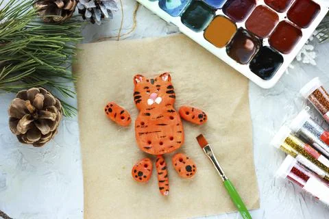 A brush with orange paint paints a tiger, DIY toys for the New Year, creative Stock Photos