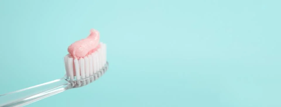 Brush with toothpaste on light blue background, space for text. Banner design Stock Photos