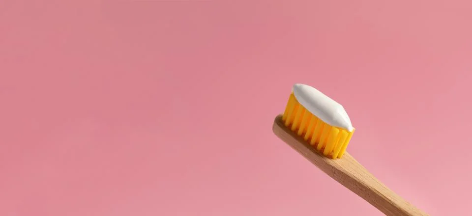 Brush with toothpaste on pink background, space for text. Banner design Stock Photos