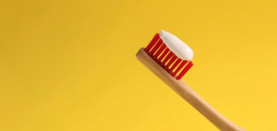 Brush with toothpaste on yellow background, space for text. Banner design Stock Photos