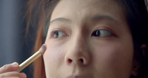 Brush under the eyes with a small brush to make the color even. Stock Footage 310015775