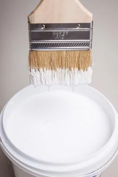Brush in white paint in hand. Stock Photos