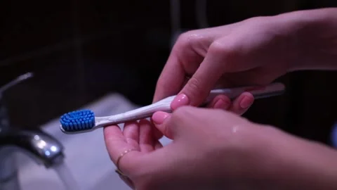 Brush your teeth in bathroom. Toothbrush in hand. hygiene procedures. Water Stock Footage 230097662