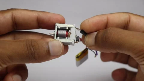Brushed dc motor with visible rotor and copper wires being tested Stock Footage 346665424