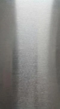 Brushed steel texture with subtle light reflections and fine linear scratches Illustrazione stock