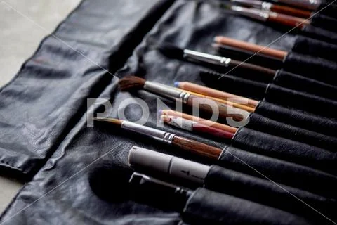 Brushes and pencils in a leather case.The artist's tools. Creativity and Stock Photos