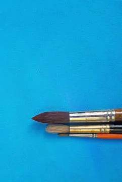 Brushes on blue painted canvas background texture Foto stock