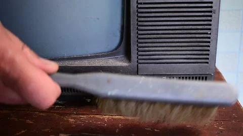 Brushes cobwebs and dust off an old TV Stock Footage 138159296