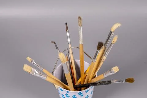 Brushes in a container for painting on a plain background Stock Photos