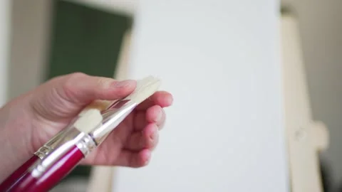Brushes for drawing in the hands of the artist close-up Stock Footage 156874483