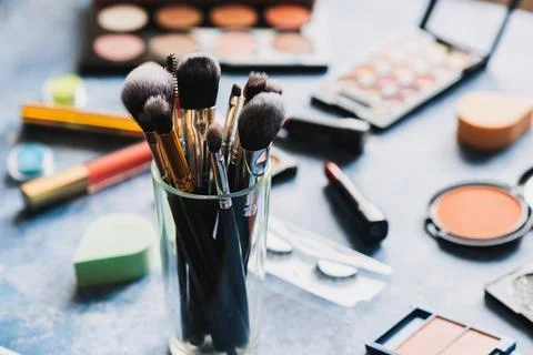 Brushes for make-up table, where lies decorative cosmetics. Stock Photos