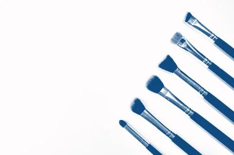 Brushes for makeup lying on white background. PANTONE Blue, Classic Blue Stock Photos