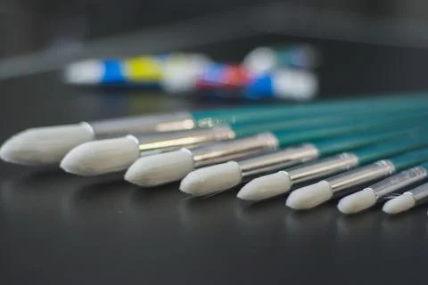 Brushes organized by size on black table Stock Photos