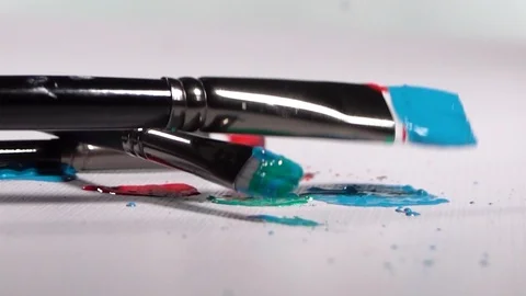 Brushes with Paint falling and Bouncing onto White Background in Slow Motion 스톡 동영상 129930906