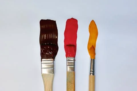 Brushes with paint on a white background Stock Photos