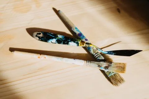 Brushes on a table backlit by the rays of the sun. Stock Photos