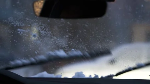 Brushes on the windshield in the car clean the snow in the evening. 4k video. Stock Footage 271675964