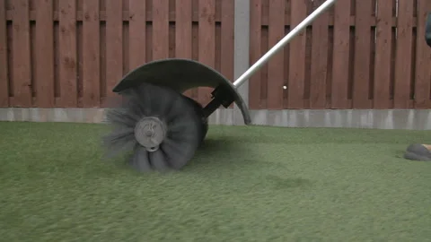 Brushing artificial synthetic grass with rotating bristle brush Stock Footage 305870642