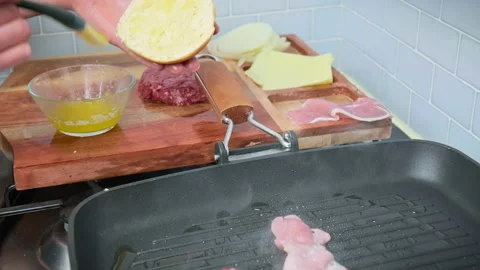 Brushing a bread bun with melted butter and placing it into a grilling pan in 4K Stock Footage 153820730