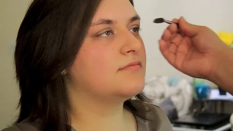Brushing brows up by makeup artist on young woman Stock Footage 105678052