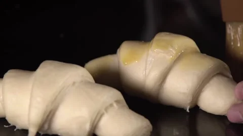 Brushing Croissant with Butter on Black Background Видео 201237053