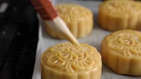 Brushing egg liquid on moon cake pastry surface before baking Stock Footage 211962514