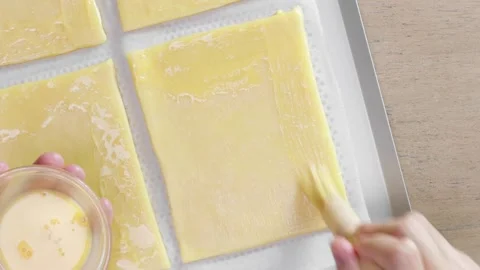 Brushing egg wash on an open pie dough Stock Footage 165126016
