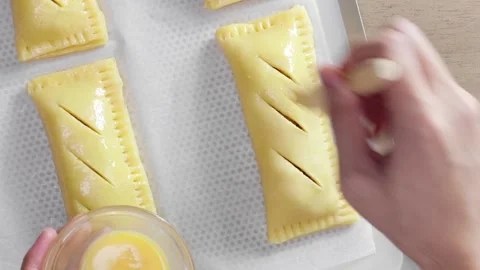 Brushing egg wash on a pie dough Stock Footage 165126118