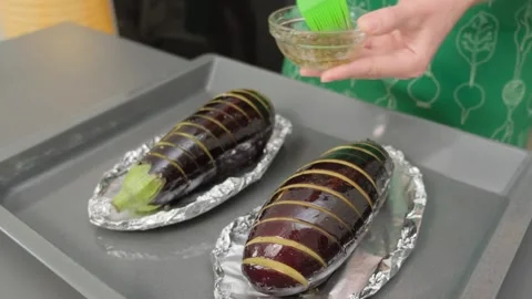 Brushing Eggplants with Oil on Baking Sheet Cooking Video stock 341426320