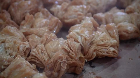 Brushing melted butter over freshly fried Argentine pastelitos Stockbeeldmateriaal 345375688