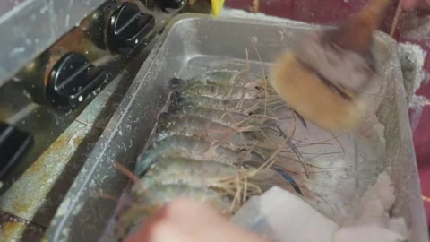 Brushing salt onto shrimp before grilling Stock Footage 342371296