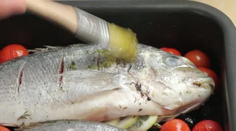 Brushing seabream with herb oil Stock Footage 24665844