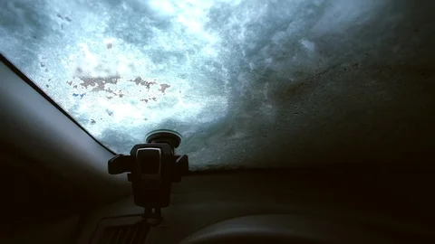 Brushing off snow from car windshield Stock Footage 100877529