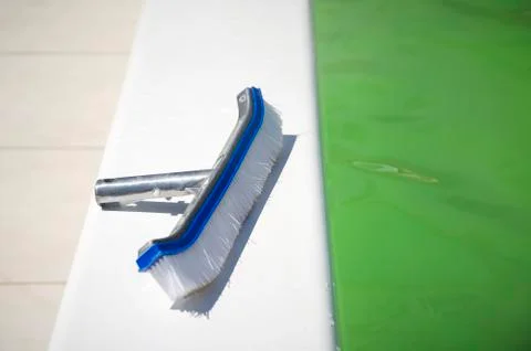 Brushing the surface of a pool to open it facing the summer season Stock Photos
