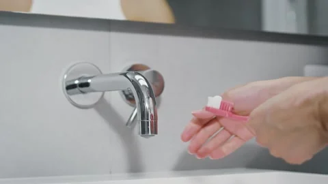 Brushing Teeth. Bathroom. Extrusion of multicolored striped toothpaste on brush Stock Footage 251555290