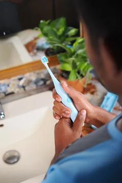 Brushing teeth with a blue toothbrush Stock Photos