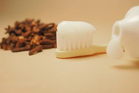 Brushing teeth with toothpaste and cloves in the background Foto stock