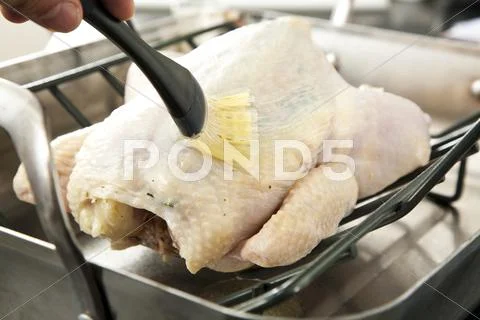 Brushing a Whole Roast Chicken with Butter Stock Photos