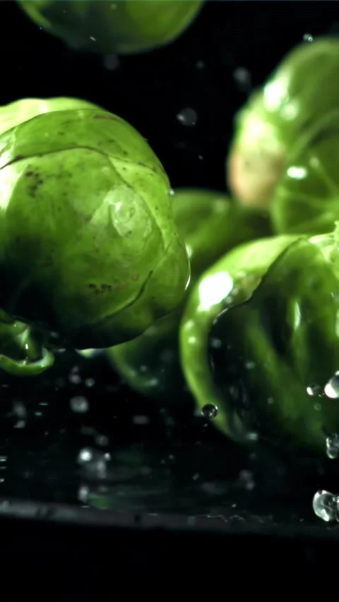 Brussel sprouts fall on a wet plate. Filmed on a high-speed camera at 1000 fps Stock Footage 335315804
