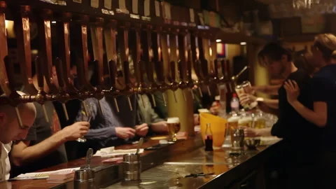 Brussels Bar Interior with Rows of Beer Taps and Bartender Serving Customers Stockbeeldmateriaal 343618621