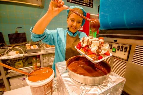 BRUSSELS, BELGIUM - 11 AUGUST, 2015: Happy lady working in belgian waffle store Stock Photos