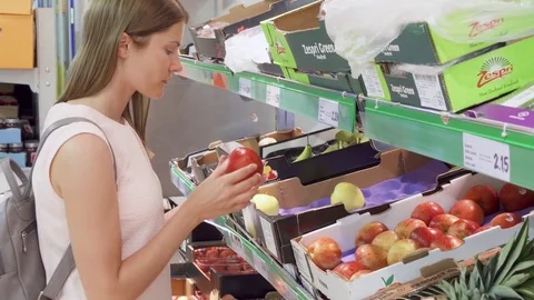 BRUSSELS, BELGIUM- CIRCA August 2017: Young woman picking out apples fruits in Stock Footage 82044891