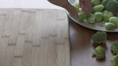 Brussels Sprouts Close Up. Hands Cutting Brussels Sprouts on a Wooden Board. Stock Footage 107633236
