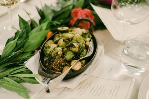 Brussels sprouts dish served at an elegant dining table with greenery Foto stock